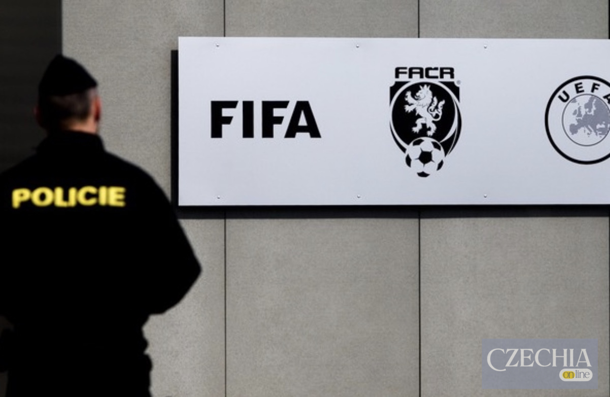 Поліцейський стоїть біля будівлі з логотипами FIFA, FAČR та UEFA. Матеріал про корупційний скандал у чеському футболі.