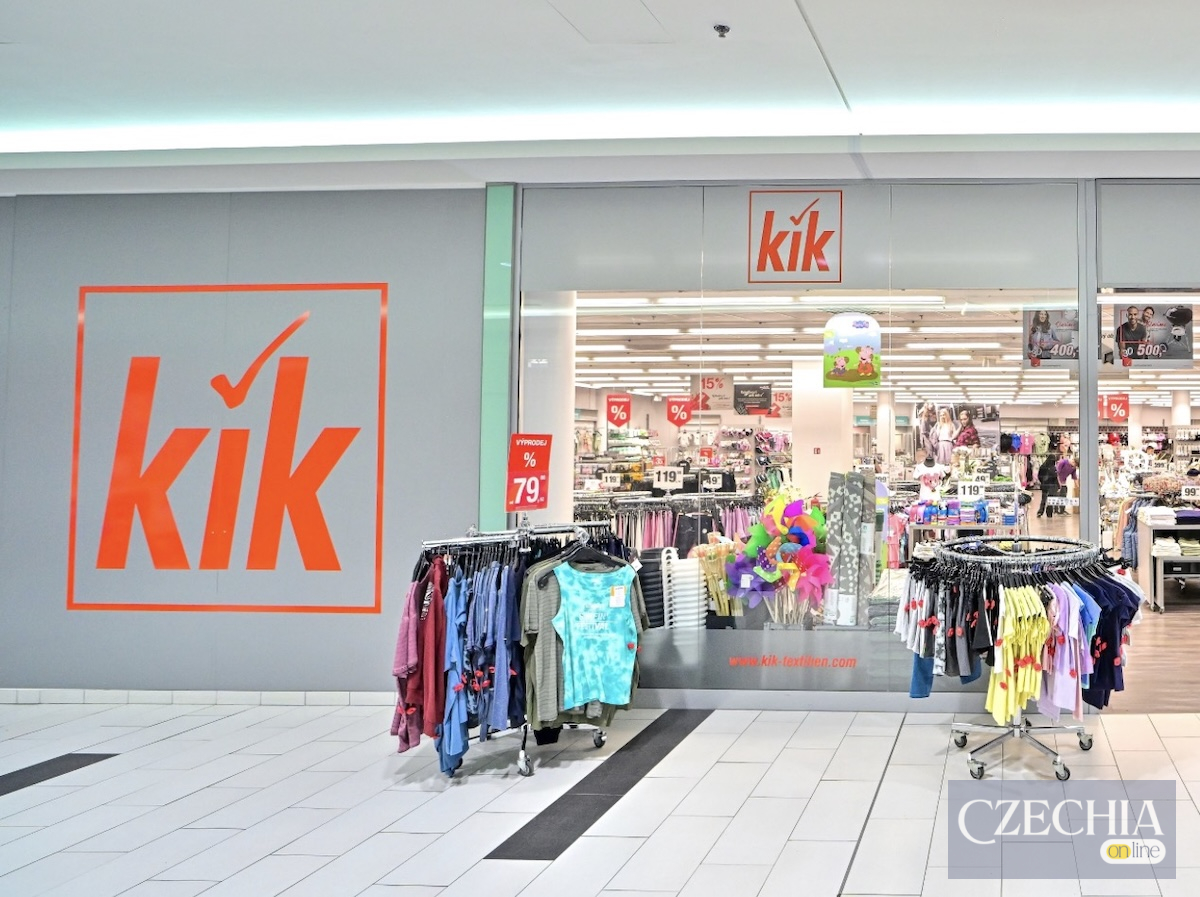 Вхід до магазину бренду KiK зі скляною вітриною та розпродажем літнього одягу. Матеріал про закриття 300 магазинів мережі у Європі.