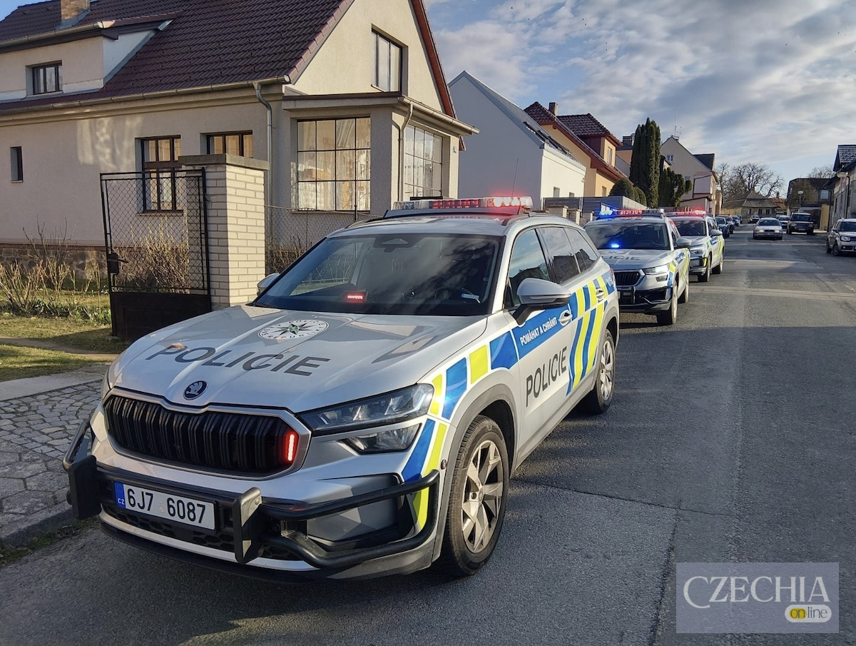 Колона поліцейських автомобілів з увімкненими мигалками припаркована на житловій вулиці. Ілюстративне фото до матеріалу про облаву біля школи.