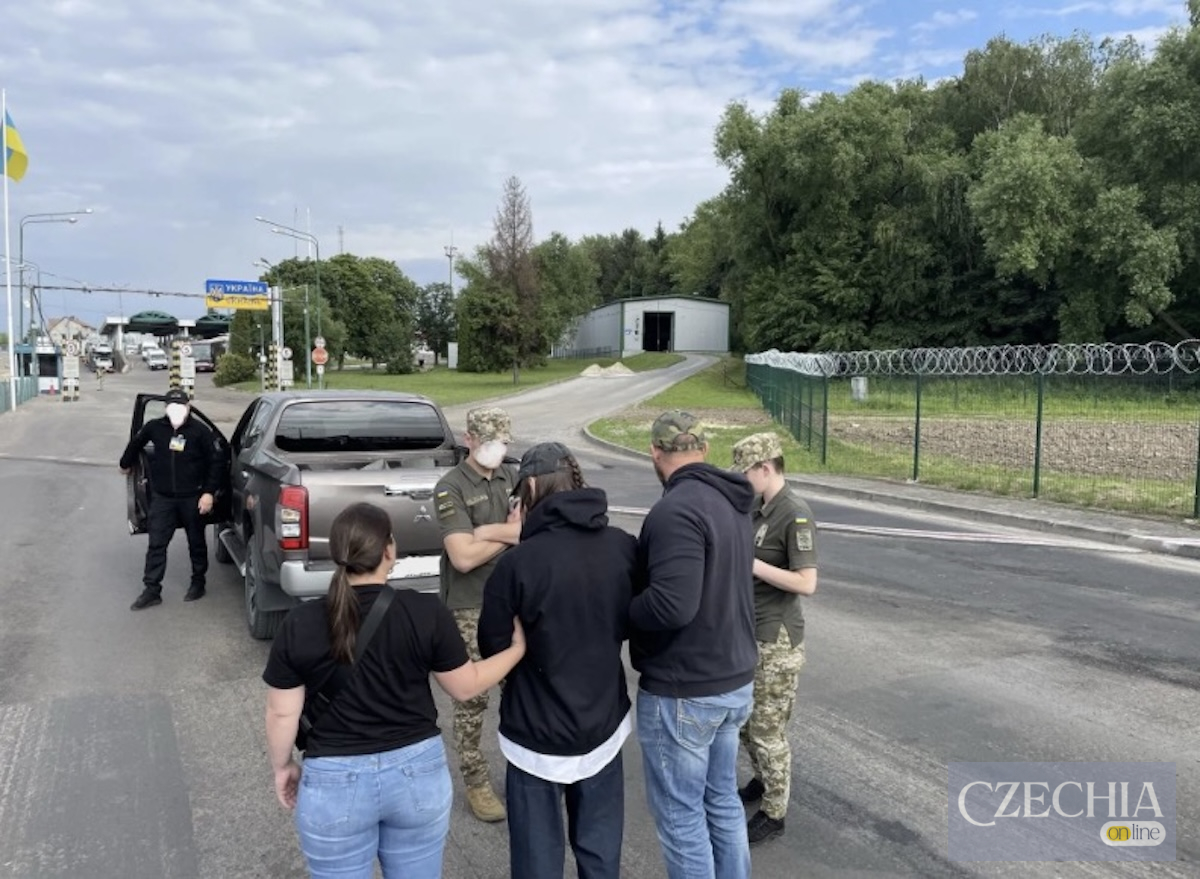 Люди в цивільному та прикордонники спілкуються біля пікапа на українському контрольно-пропускному пункті.