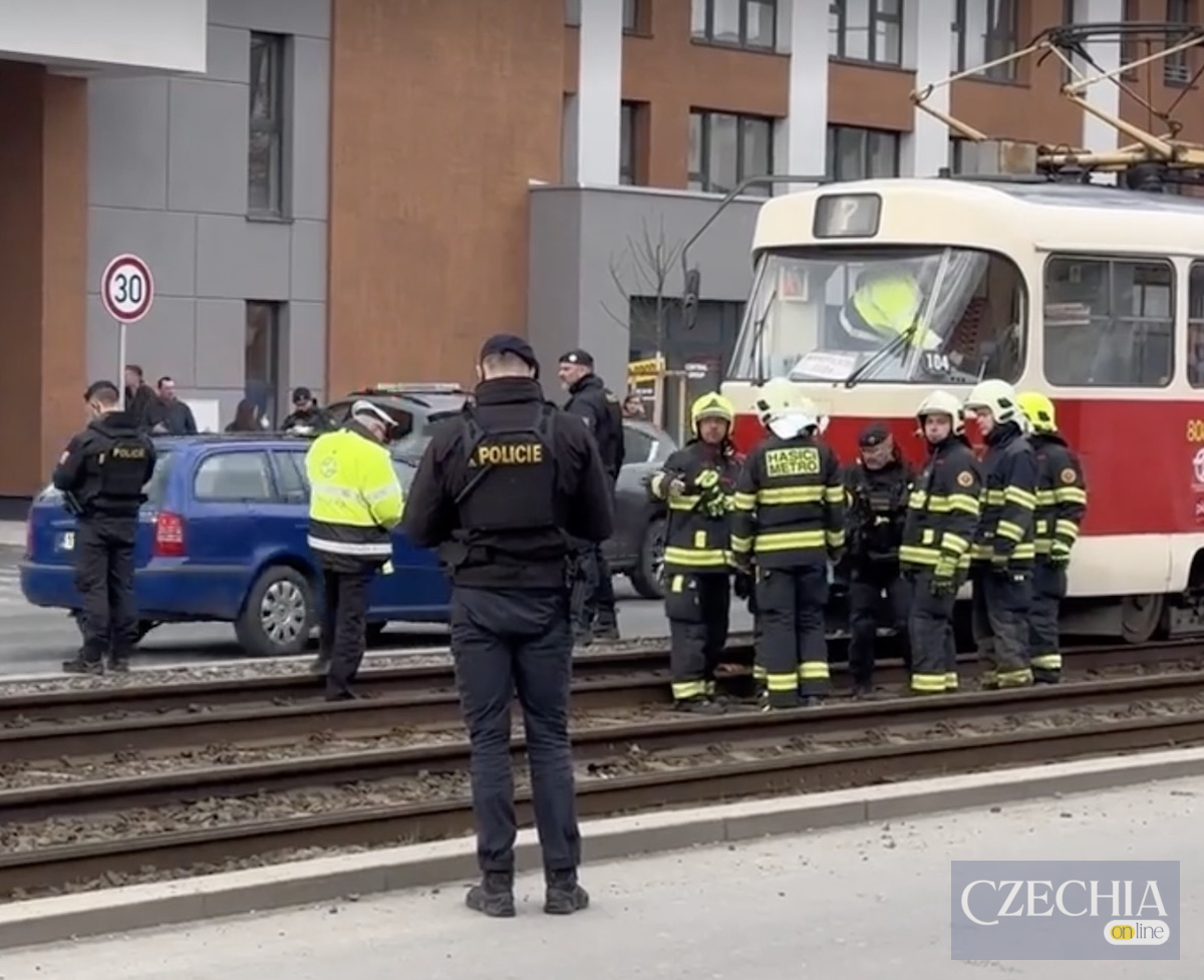 Поліцейські та пожежники працюють на трамвайних коліях біля зупиненого червоно-білого вагона.