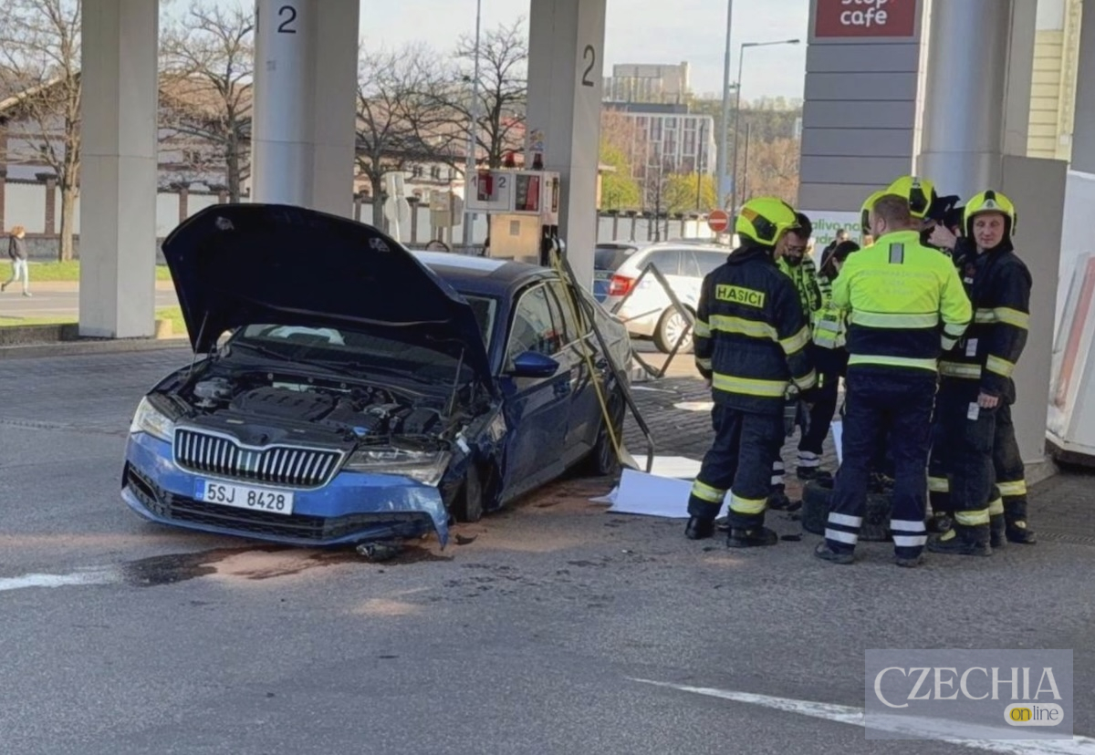 Розбитий синій легковик Škoda врізався в колонку на заправці в Празі. Навколо стоять пожежники. Матеріал про ДТП в районі Голешовіце.