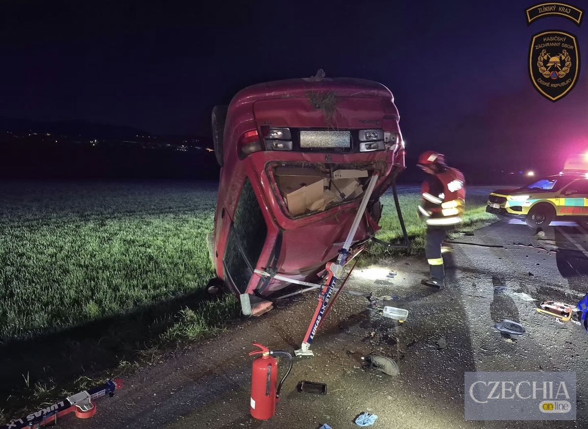 Рятувальники працюють біля понівеченого червоного автомобіля, який перекинувся після ДТП на нічній трасі.