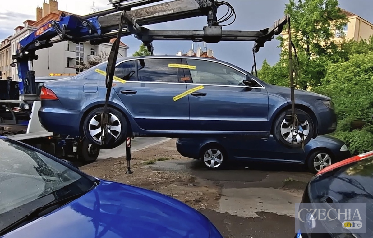 Евакуатор підіймає синьо-сіру Skoda Superb, опечатану жовтими стрічками поліції Чехії.