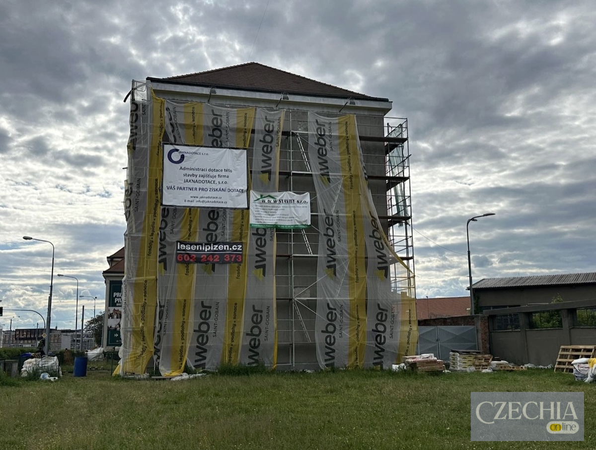 Житловий будинок у процесі ремонту, повністю закритий будівельними риштуваннями та захисною плівкою у Плзні. Матеріал про спробу пограбування через фасад.