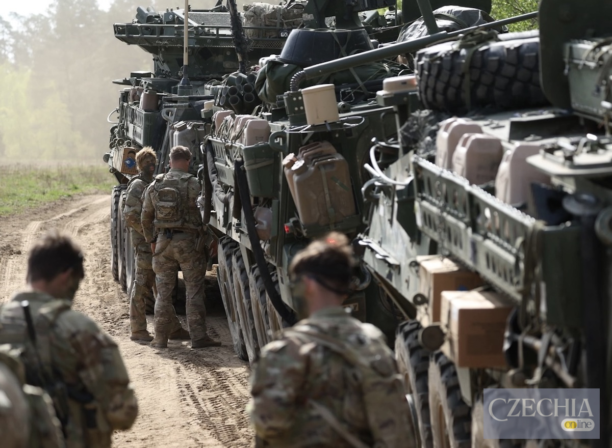 Група американських військових у камуфляжній формі стоїть поруч із важкими бронемашинами на ґрунтовій дорозі. Матеріал про перекидання військ США до Польщі.
