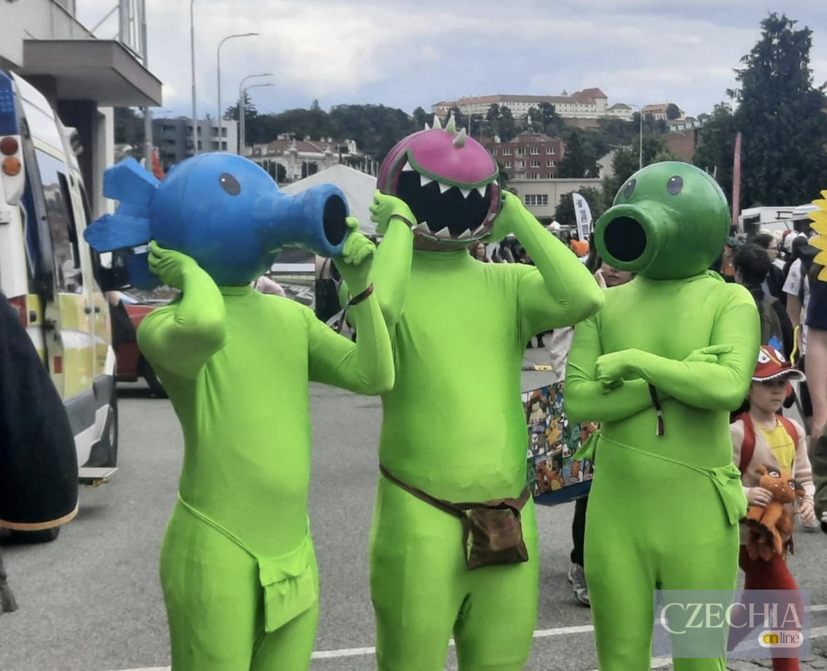 Троє людей у зелених костюмах та великих масках персонажів з гри Plants vs. Zombies на фестивалі. Матеріал про заходи безпеки на Animefest у Чехії.