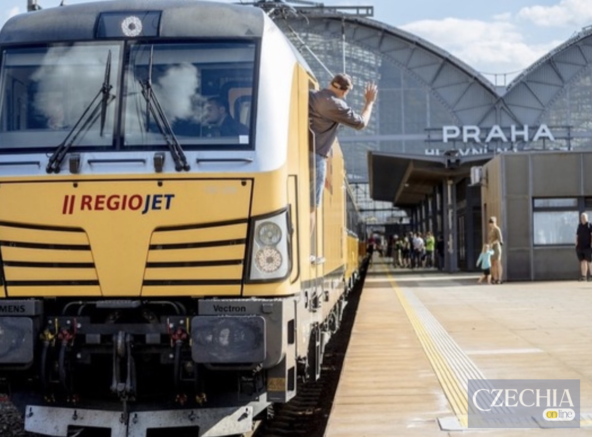 Жовтий локомотив потяга RegioJet на платформі Головного вокзалу Праги. З вікна кабіни махає рукою машиніст. Матеріал про затримку рейсу.