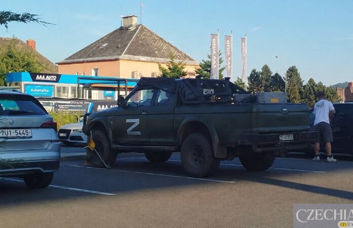 Темно-зелений пікап із великою білою літерою Z на дверцятах, припаркований у місті.