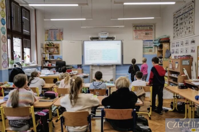 Учні в класі чеської школи під час уроку дивляться на інтерактивну дошку.