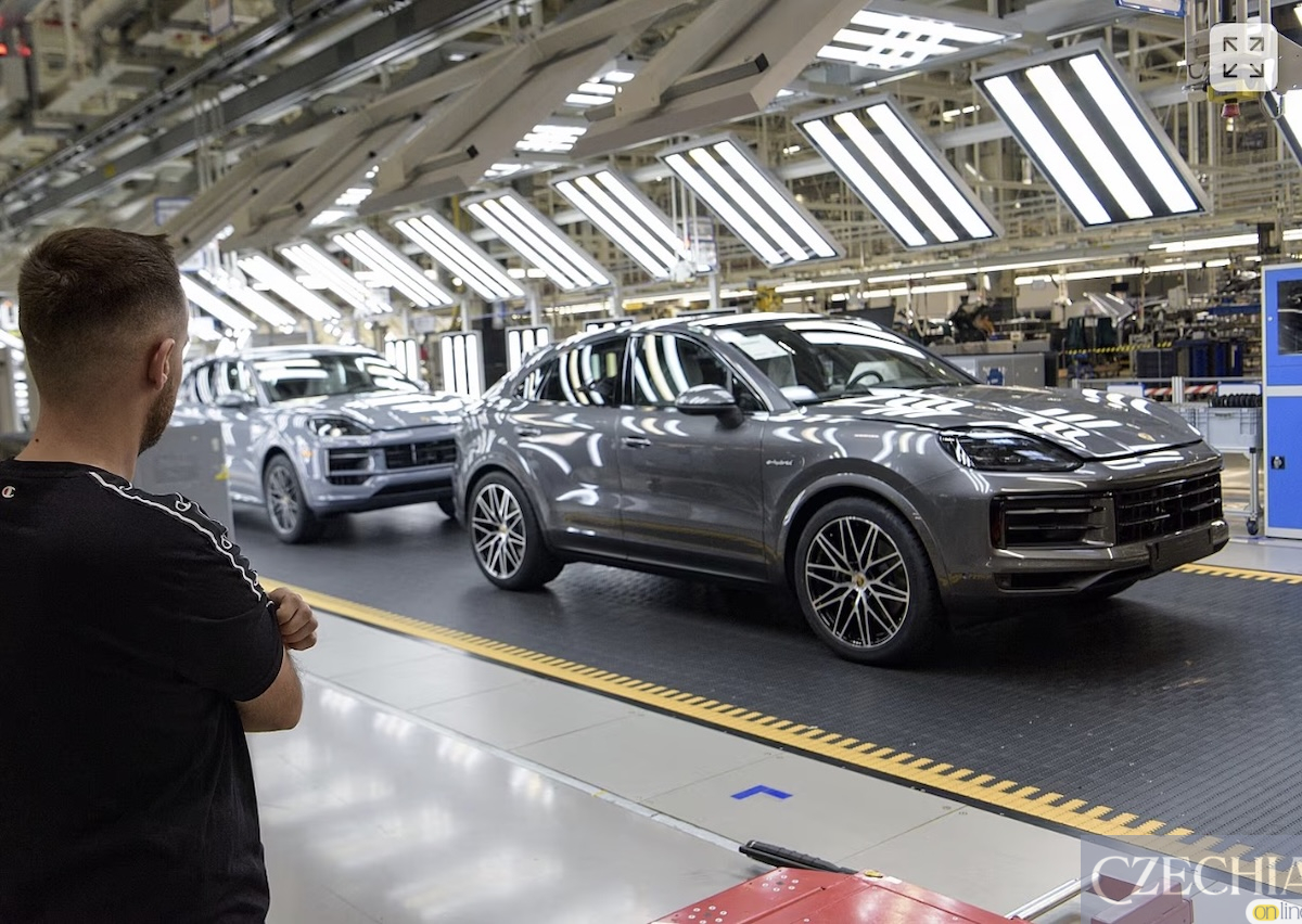 Працівник біля конвеєра з новими автомобілями Porsche Cayenne на автозаводі.