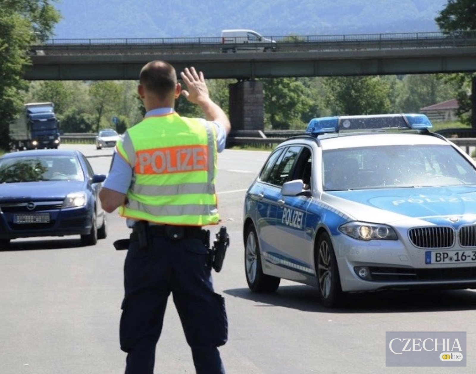 Німецький поліцейський біля патрульного автомобіля на дорозі