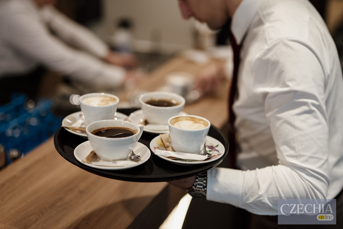 Serving_coffee_in_a_cafe_during_the_morning_hours_with_a_waiter_carrying_a_tray_of_drinks_for_customers